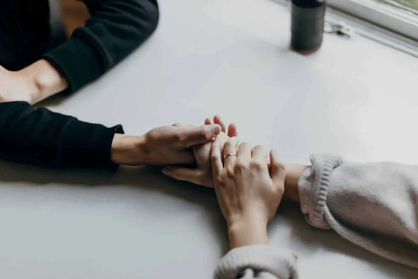 Dos personas se cogen de las manos sobre una mesa